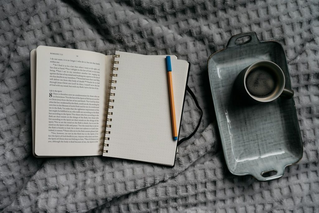 Carnet et boisson posés sur un lit pour une routine du soir